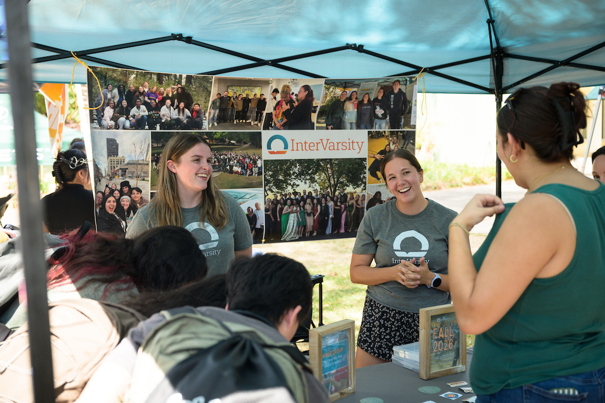 InterVarsity students talking with classmates at an outdoor welcome booth