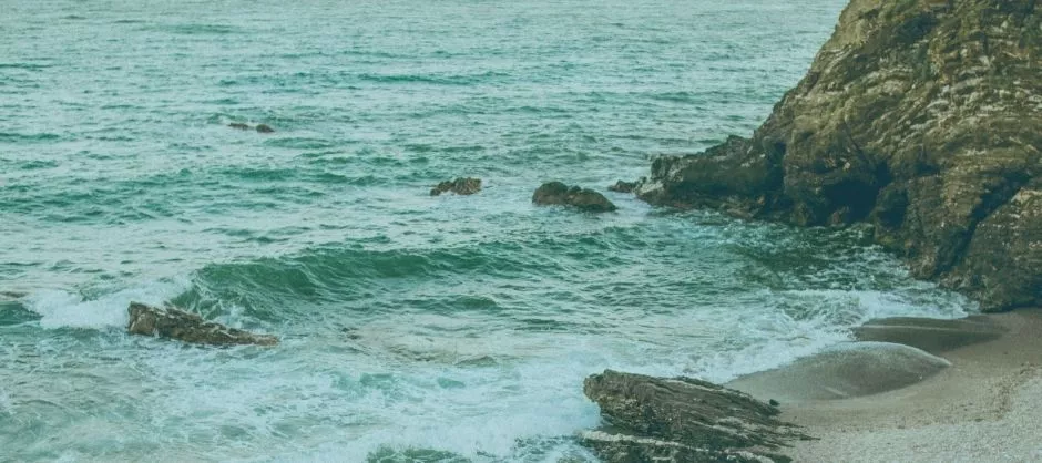 a photo of an ocean shore with waves lapping on the beach
