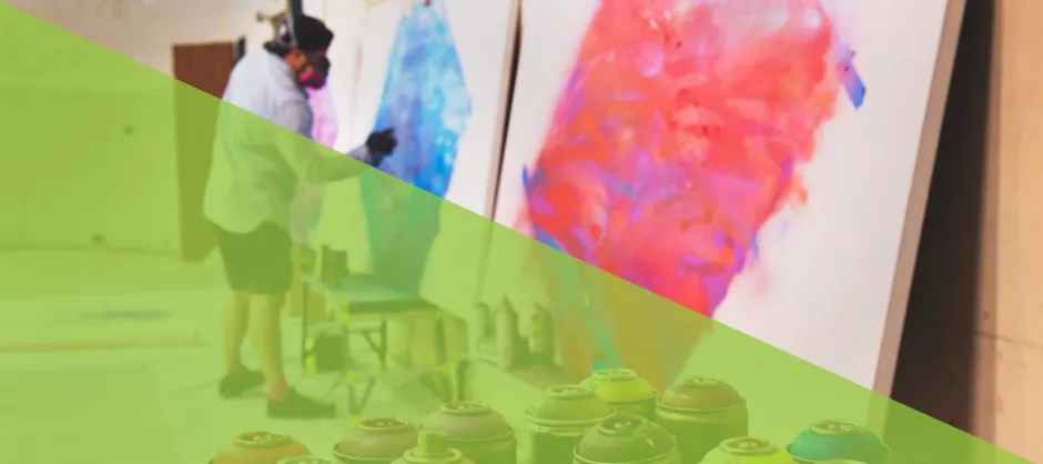 an artist working with spray paints on canvas