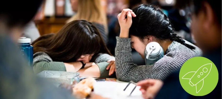 two students bowing their heads in prayer together