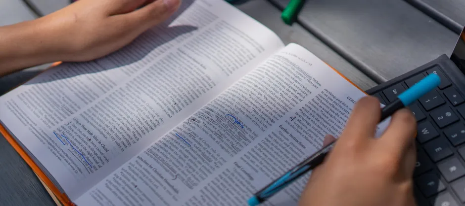 Hands resting on an open Bible.