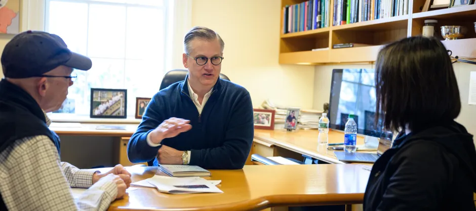 3 people talking at a desk