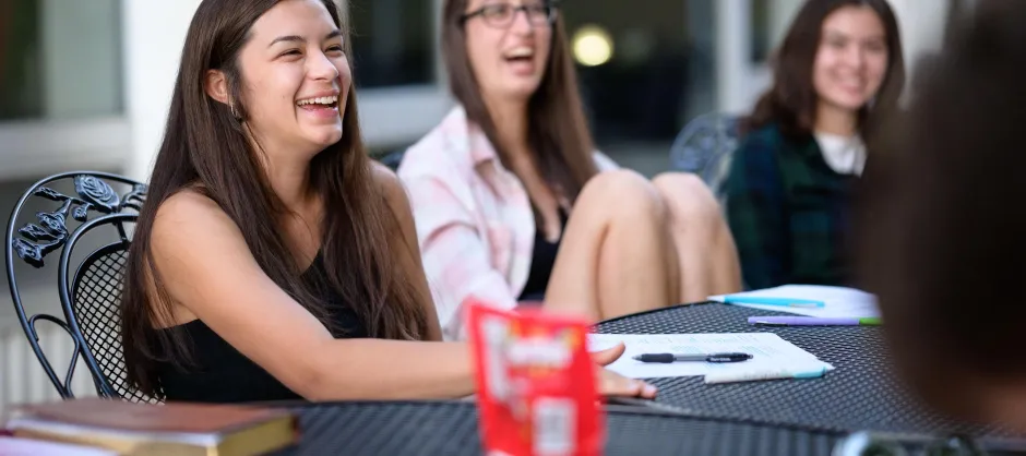 woman laughing while sitting at a table