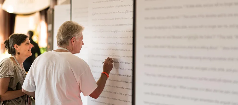 A man marking up a poster sized manuscript. There are circles and underlines on the manuscript.