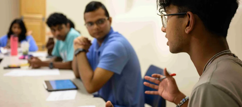 Several individuals around a table, focused on their laptops, collaborating on a project or sharing ideas.