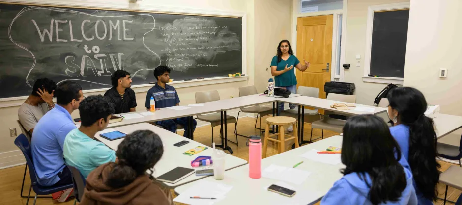 A group of people seated at tables in a classroom, engaged in discussion and Bible Study..