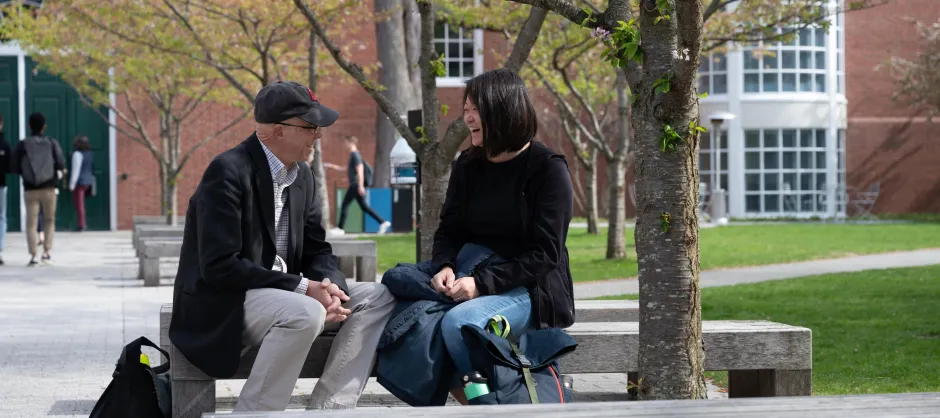 Two faculty members talking while sitting