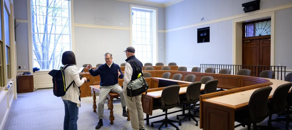 Three faculty members talking in a classroom