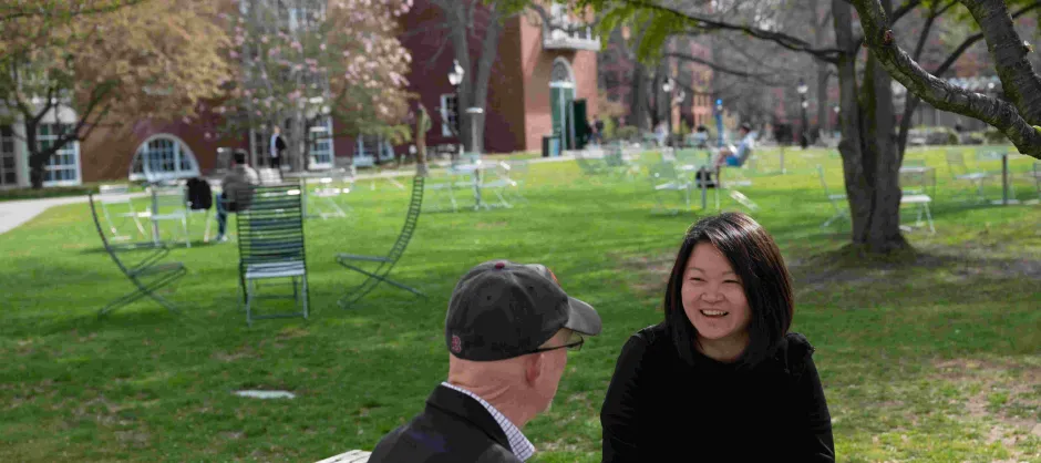 two faculty talking with each other on campus