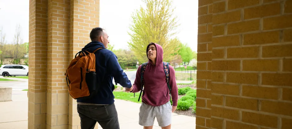 Two college students shaking hands