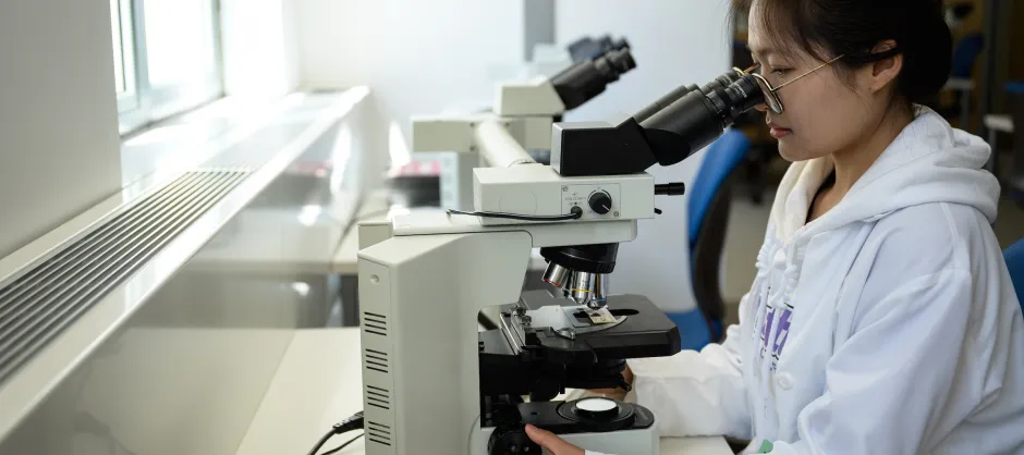 Woman looking through a microscope