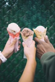 three ice cream cones, held by three people