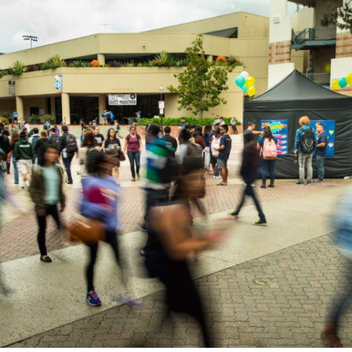 A proxe station set up in the midst of a busy campus plaza