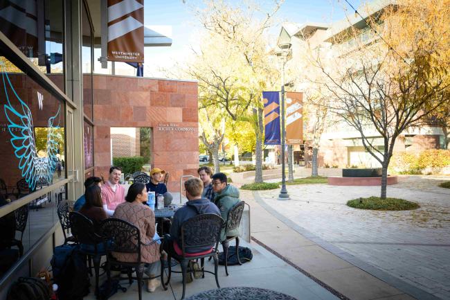 Students sitting around a table on campus